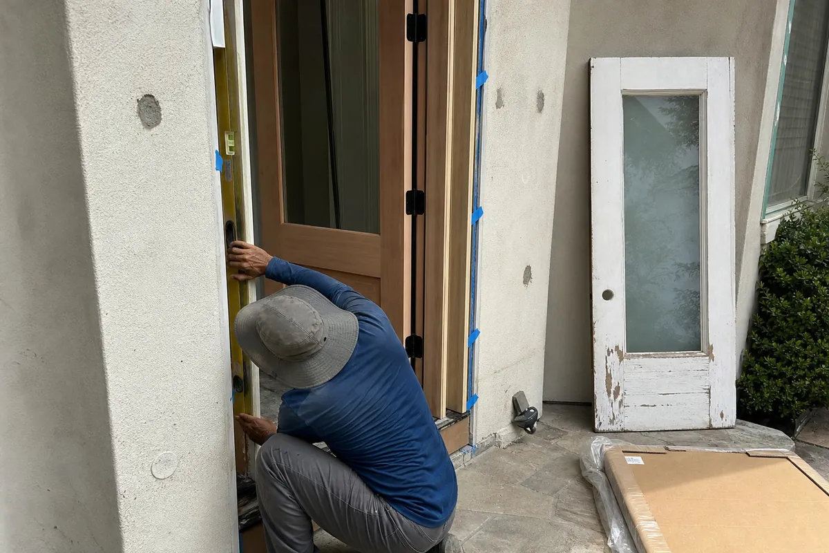Fitting a new exterior entry door into its frame at a Malibu home